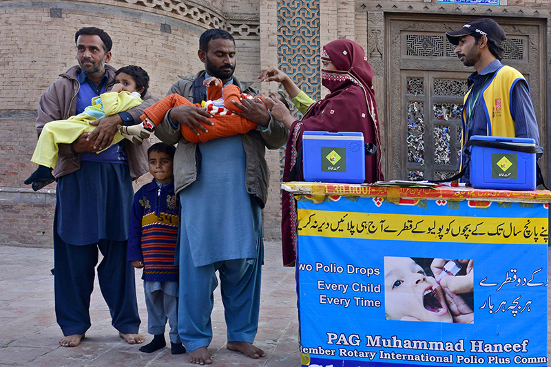 Polio workers vaccinating child at transit point in pakistan.
